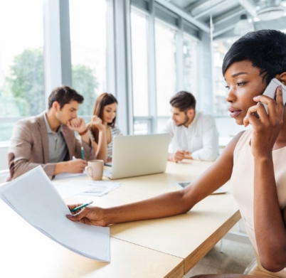 serious-businesswoman-with-documents-talking-on-P9Q6LX6@2x-min